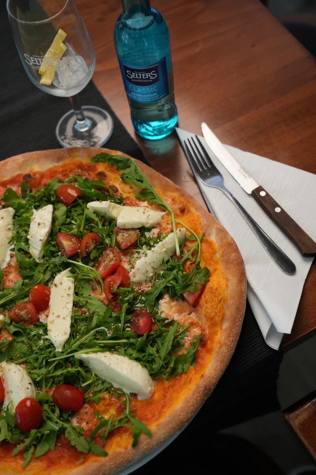 Pizza mit Rucola und gehobeltem Parmesan
