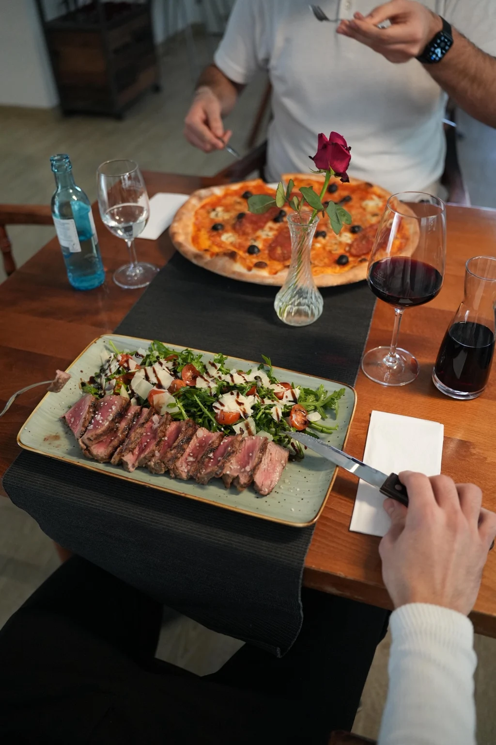 Fleischgericht und Pizza am Tisch